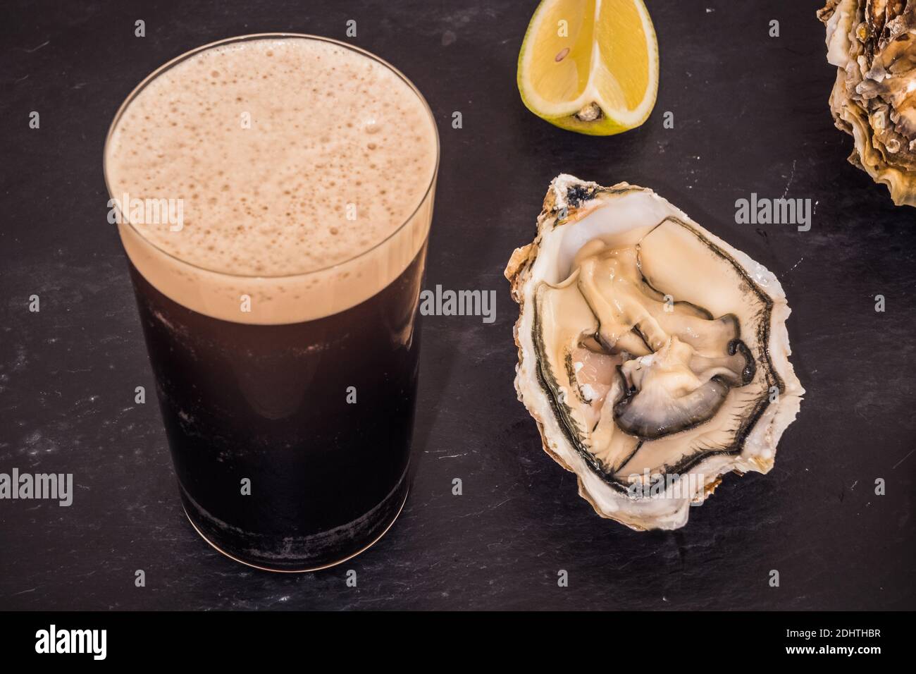 Raw Oyster and Stout with a Lemon Wedge, an Irish Cuisine Speciality Stock Photo