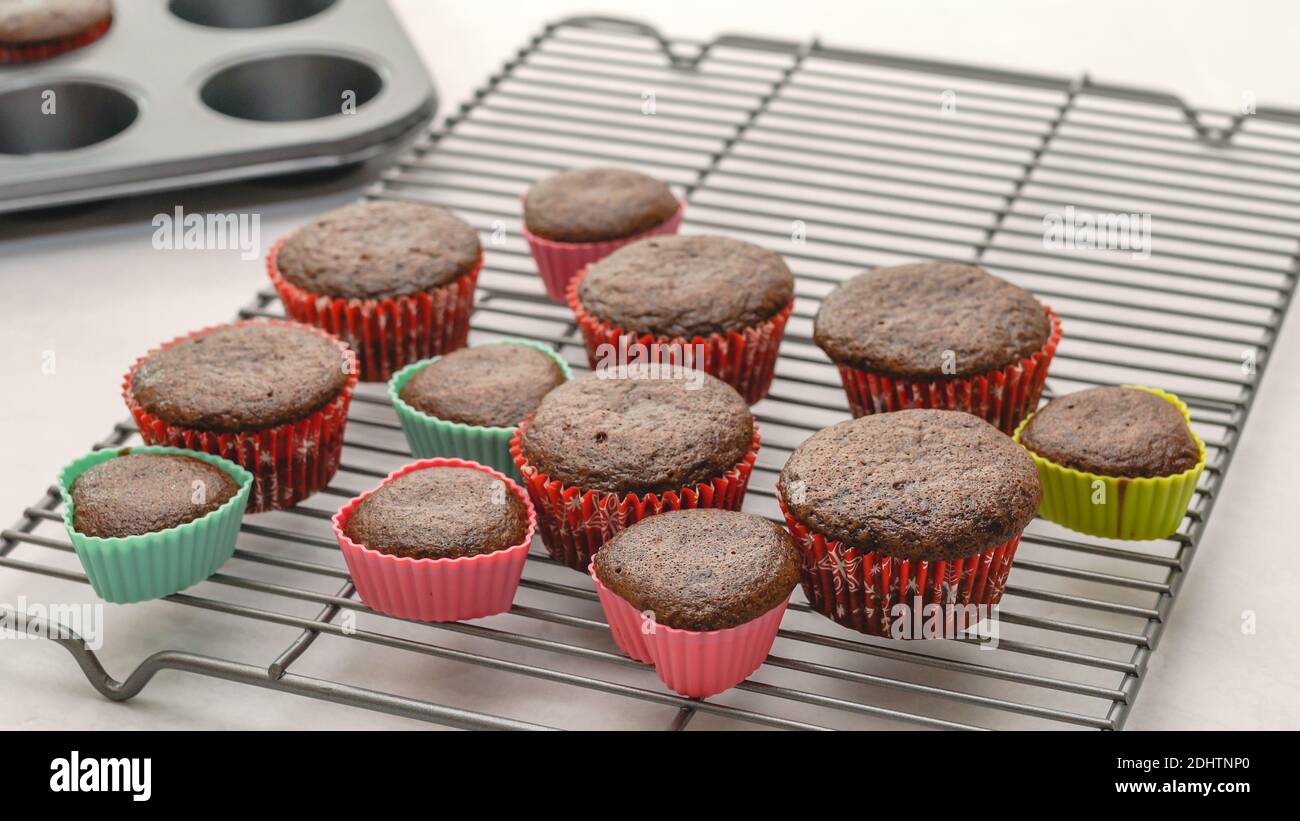 Chocolate cupcakes close up on cooling rack on light grey background Stock Photo