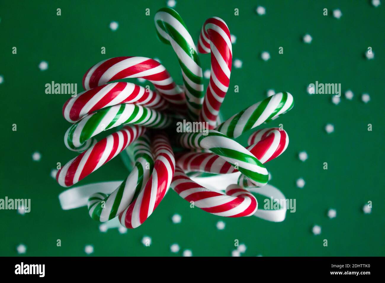Christmas background with candy canes. Green and red sweet sticks in