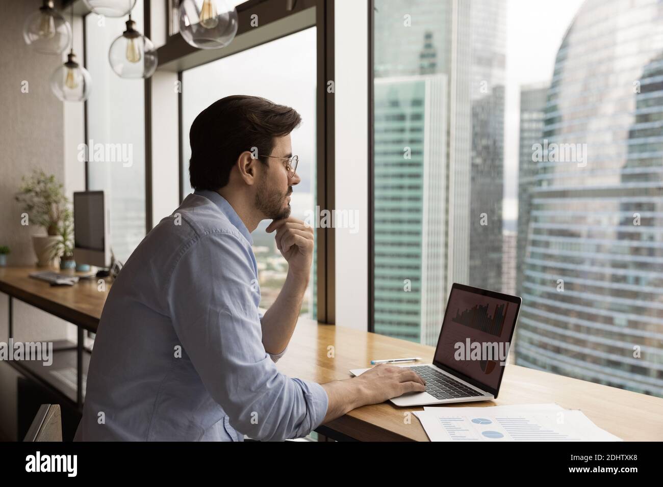 Pensive Caucasian man work on laptop thinking Stock Photo