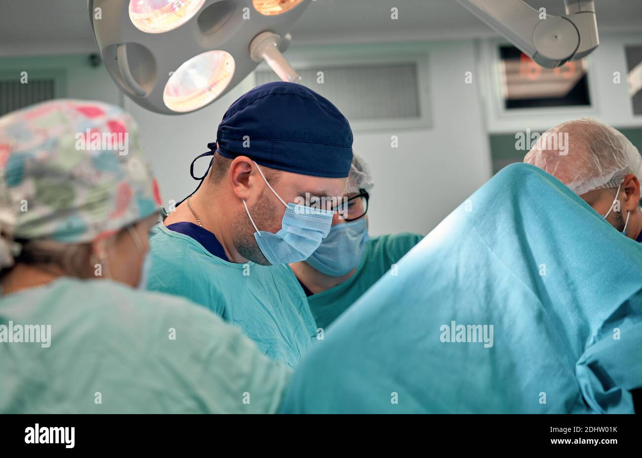 Physicians in Surgery looking down at patient Stock Photo - Alamy