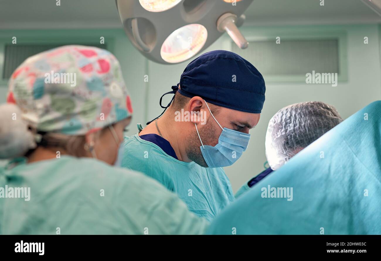 Physicians in Surgery looking down at patient Stock Photo - Alamy
