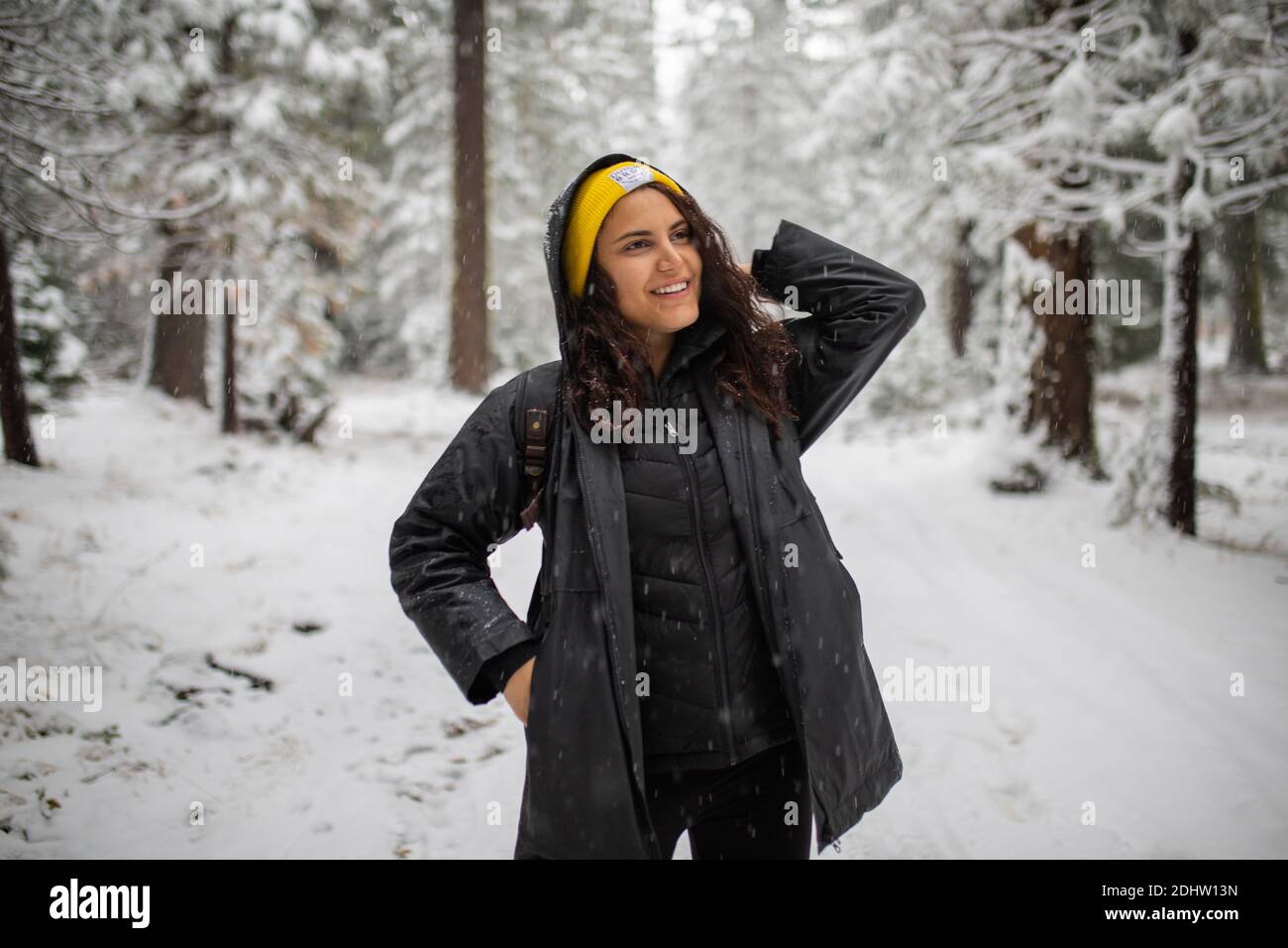 Happy woman standing in the middle of a snowy forest Stock Photo - Alamy