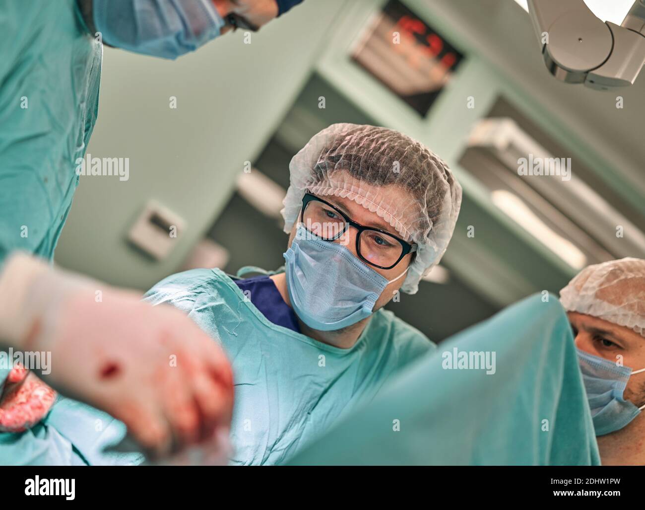Physicians in Surgery looking down at patient Stock Photo - Alamy