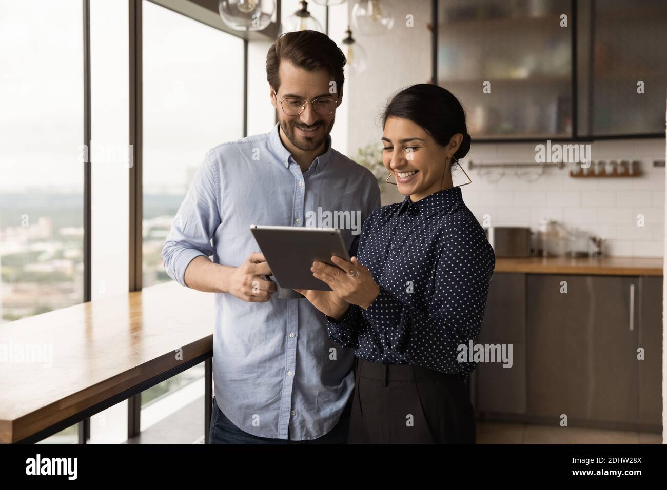 Smiling diverse employees cooperate using tablet in office Stock Photo