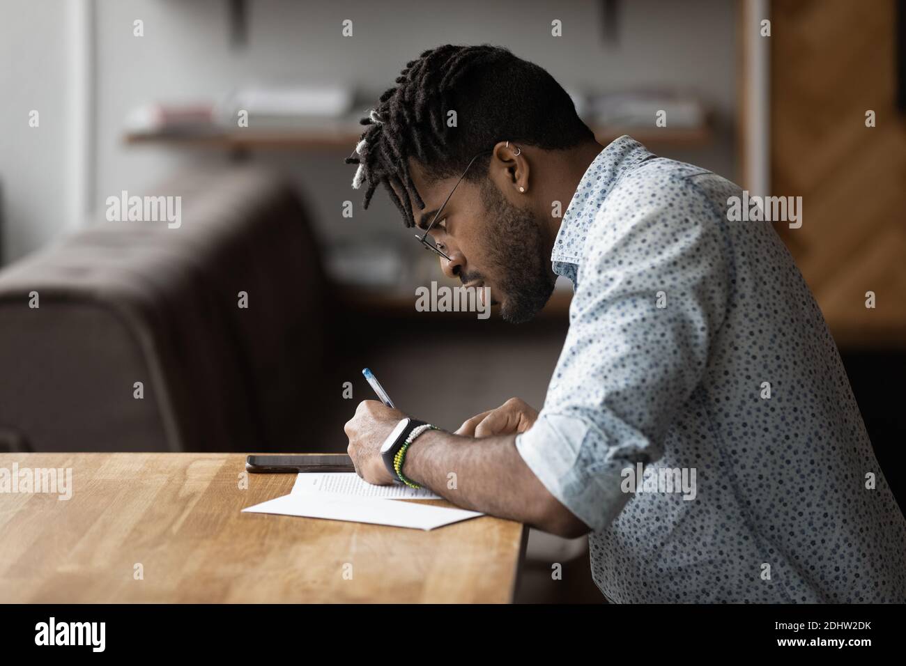 African American man make notes using cellphone Stock Photo