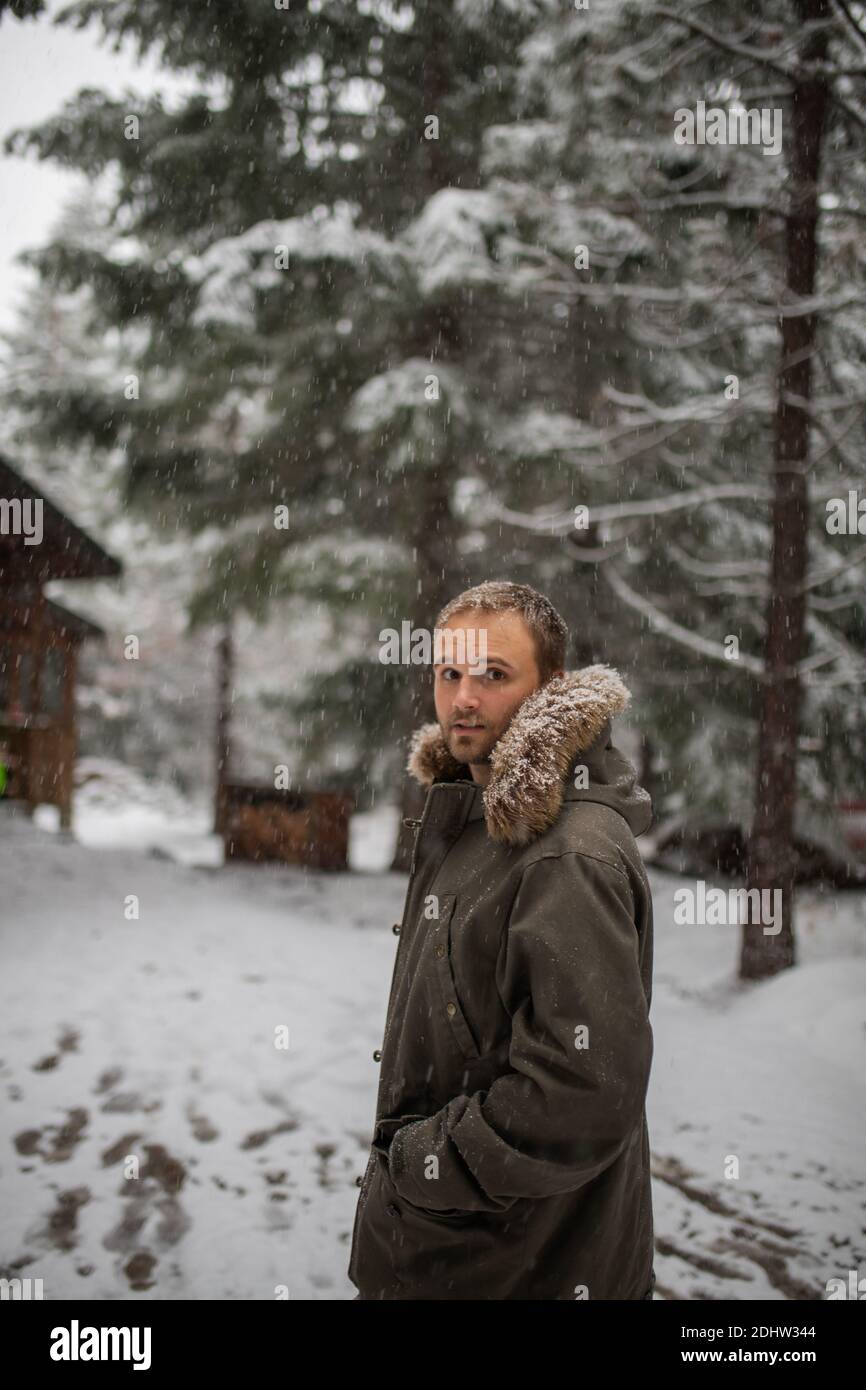 Handsome man standing in the middle of a snowy forest Stock Photo - Alamy