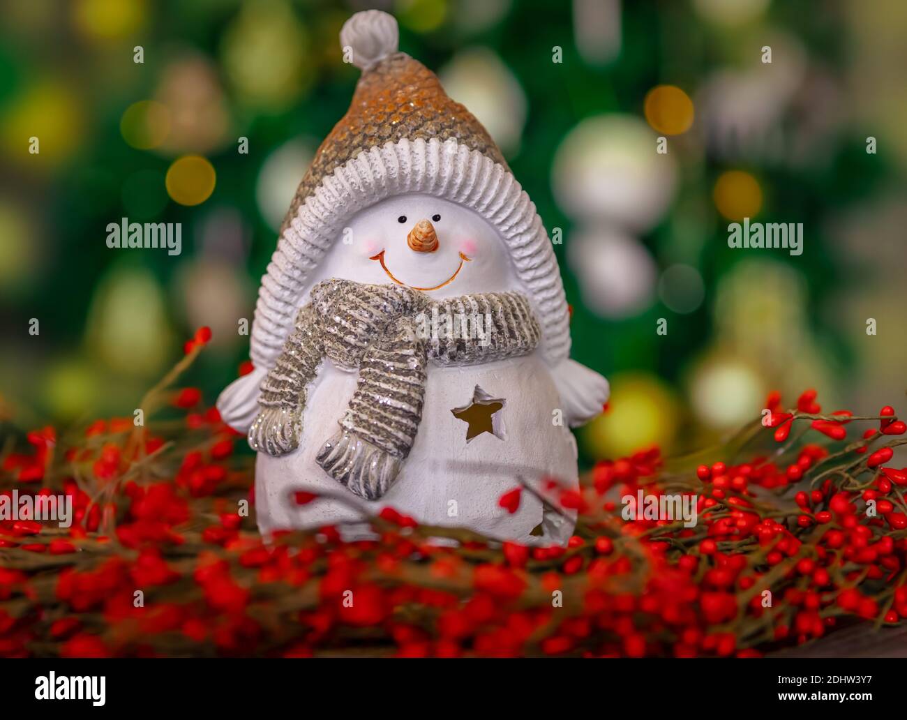 https://c8.alamy.com/comp/2DHW3Y7/beautiful-christmas-home-decoration-cute-little-snowman-toy-standing-in-the-red-berries-wreath-on-the-table-over-glowing-xmas-tree-bokeh-lights-2DHW3Y7.jpg