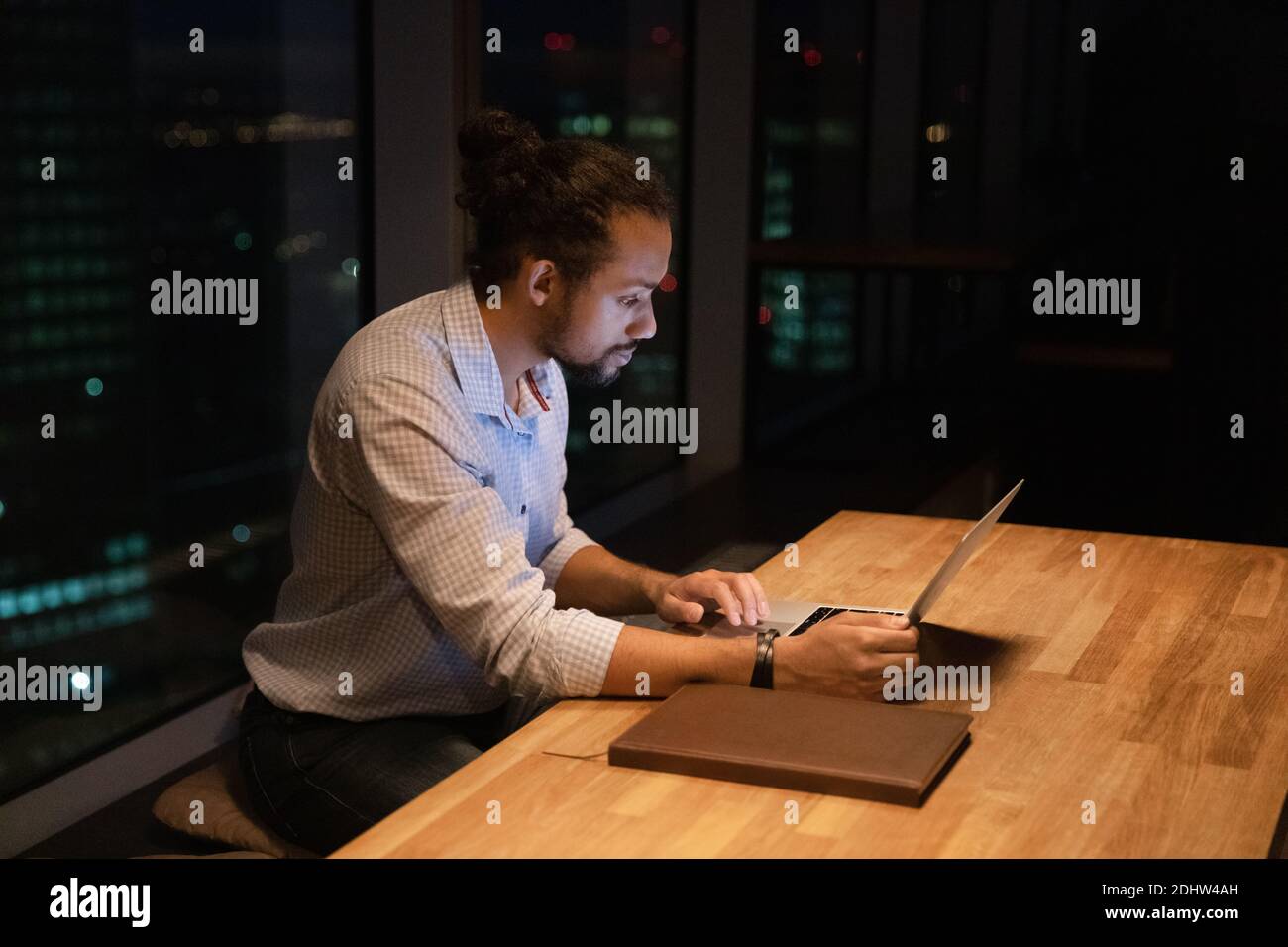 Focused biracial man worker stay in office late Stock Photo