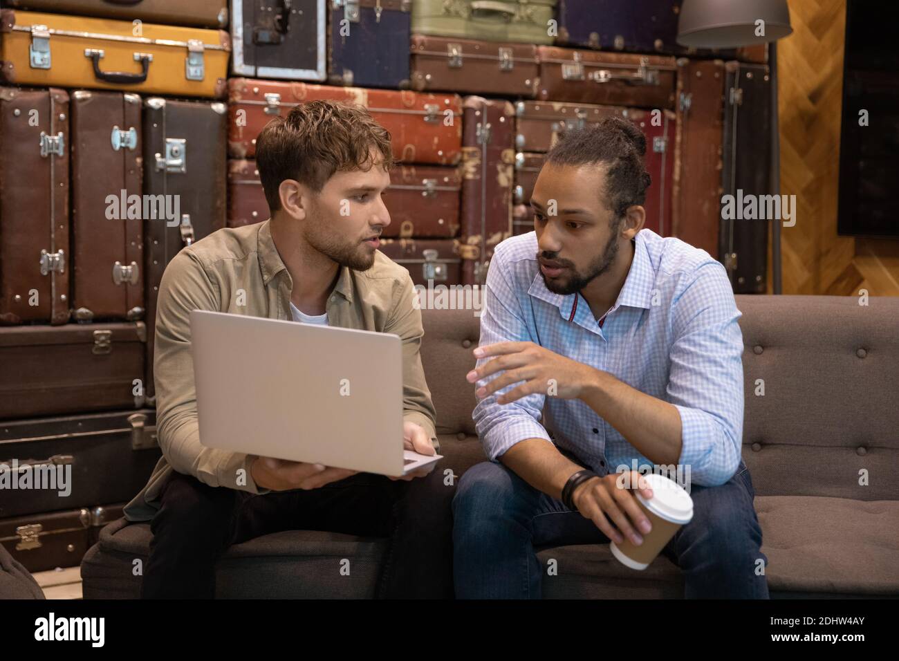 Multiracial colleagues brainstorm working on laptop together Stock Photo