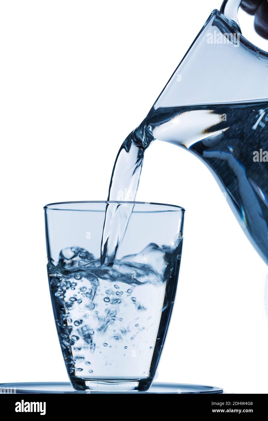 Ein Krug aund ein  Glas mit Wasser vor weissem Hintergrund, Symbolfoto für Trinkwasser, Wasserbedarf und Verbrauch, Glas, Stock Photo