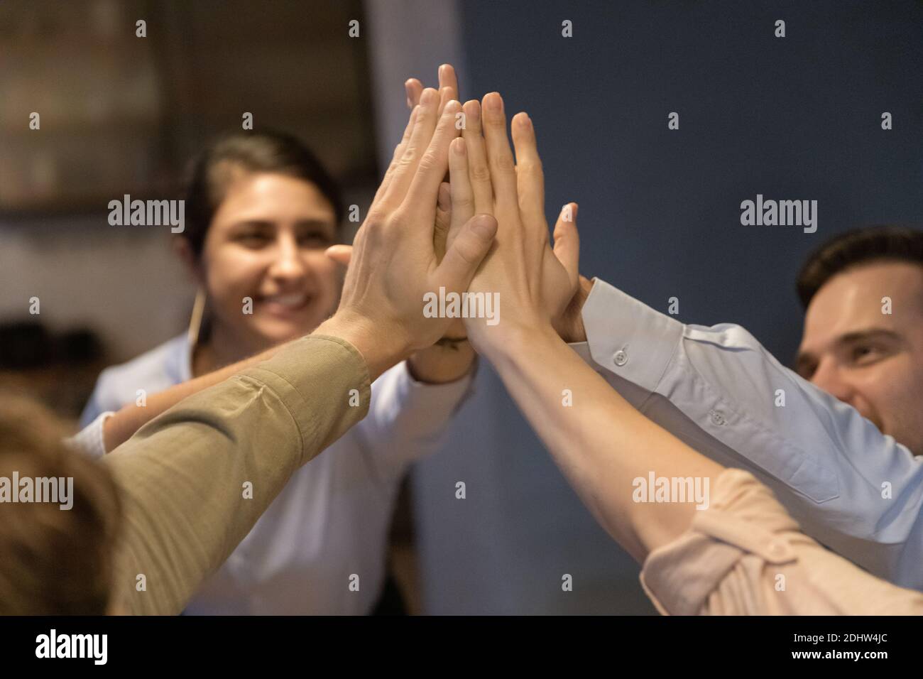 Excited multiracial employees give high five at meeting Stock Photo - Alamy