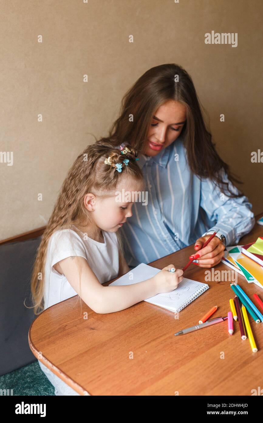 Mother helping her child to do homework at home Stock Photo - Alamy