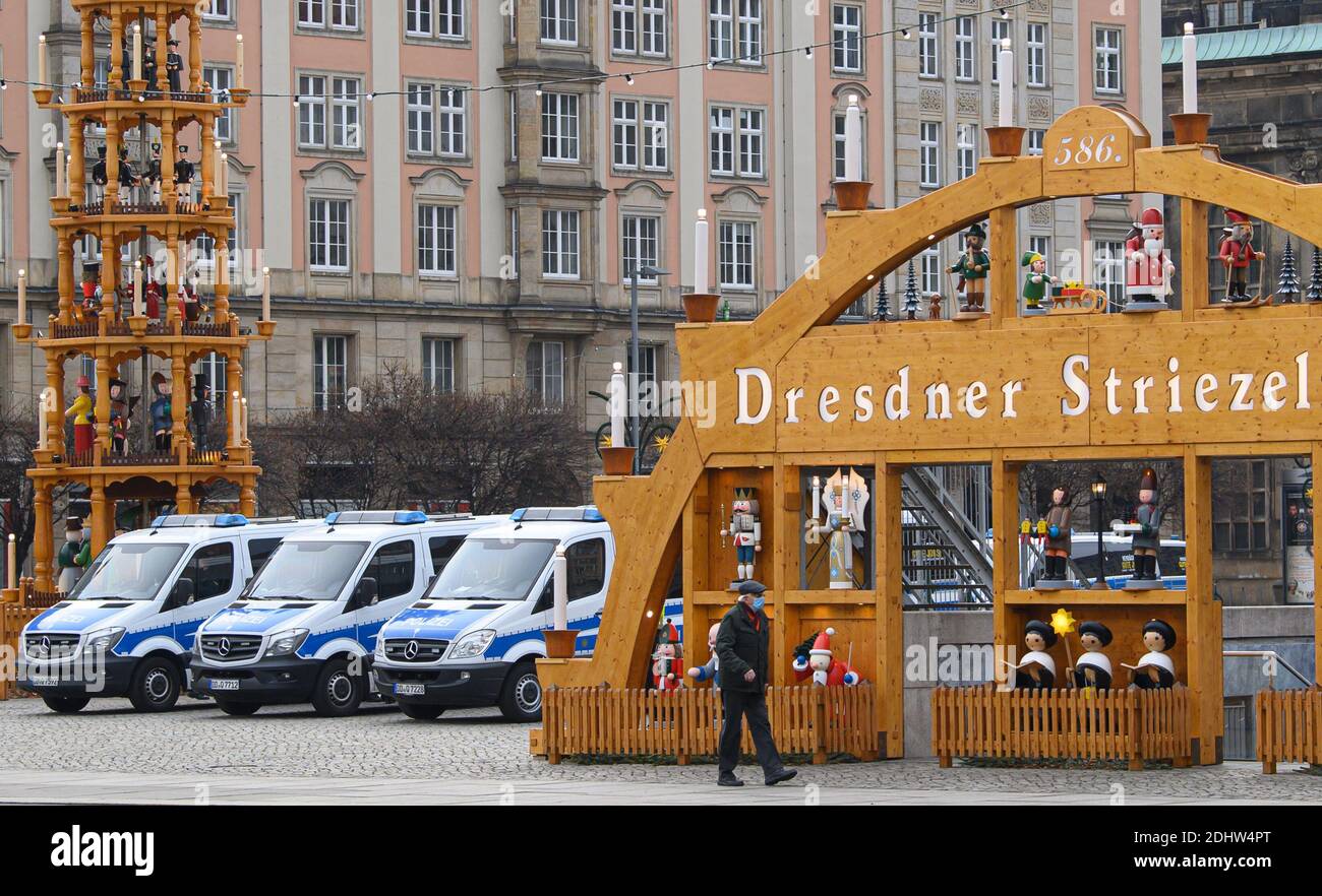 Dresden, Germany. 12th Dec, 2020. Police vehicles are parked at the Striezelmarkt on the Altmarkt between a Christmas pyramid and a Schwibbogen (candle arch). The city of Dresden has prohibited a demonstration by the Querdenken 351 Dresden initiative against the Corona policy. Credit: Robert Michael/dpa-Zentralbild/dpa/Alamy Live News Stock Photo