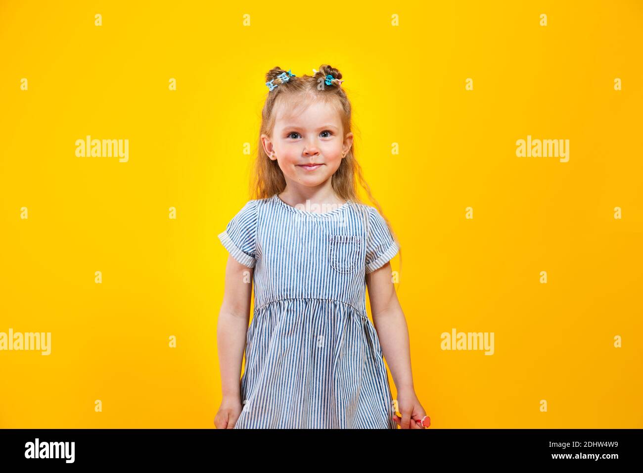 Happy caucasian child girl smiling to camera over yellow background ...
