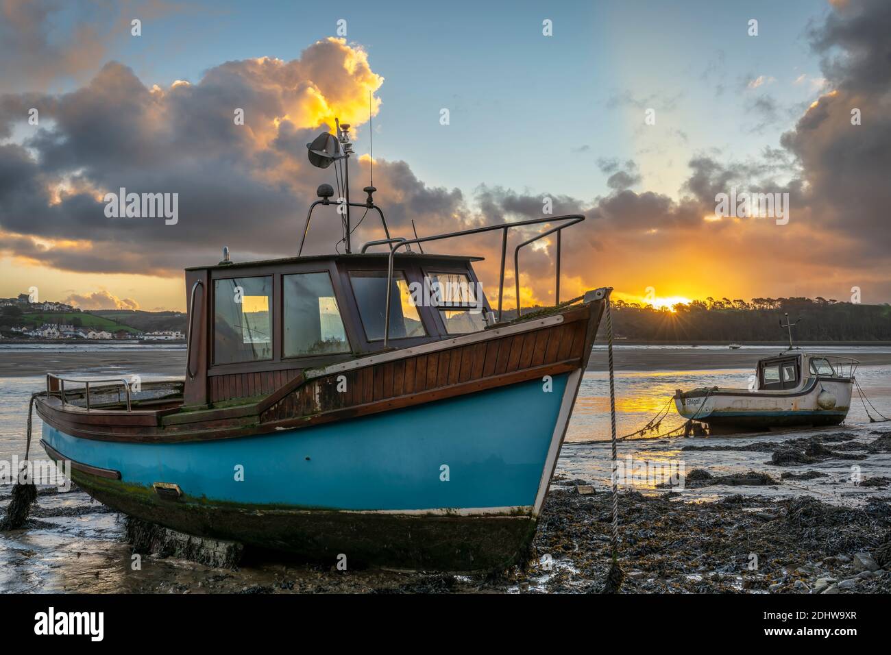 Appledore, North Devon, England. Saturday 12th December 2020. UK Weather. A cold and breezy start to the day in North Devon as the sun rises over the River Torridge, lighting up the fishing boats moored along the estuary, at the coastal village of Appledore. Credit: Terry Mathews/Alamy Live News Stock Photo