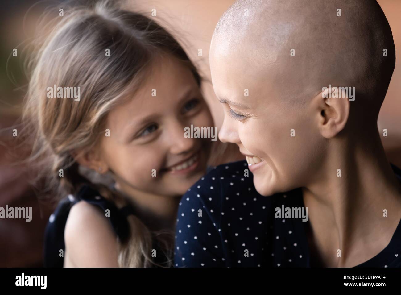 Close up happy cancer sick mother and little daughter hugging Stock Photo