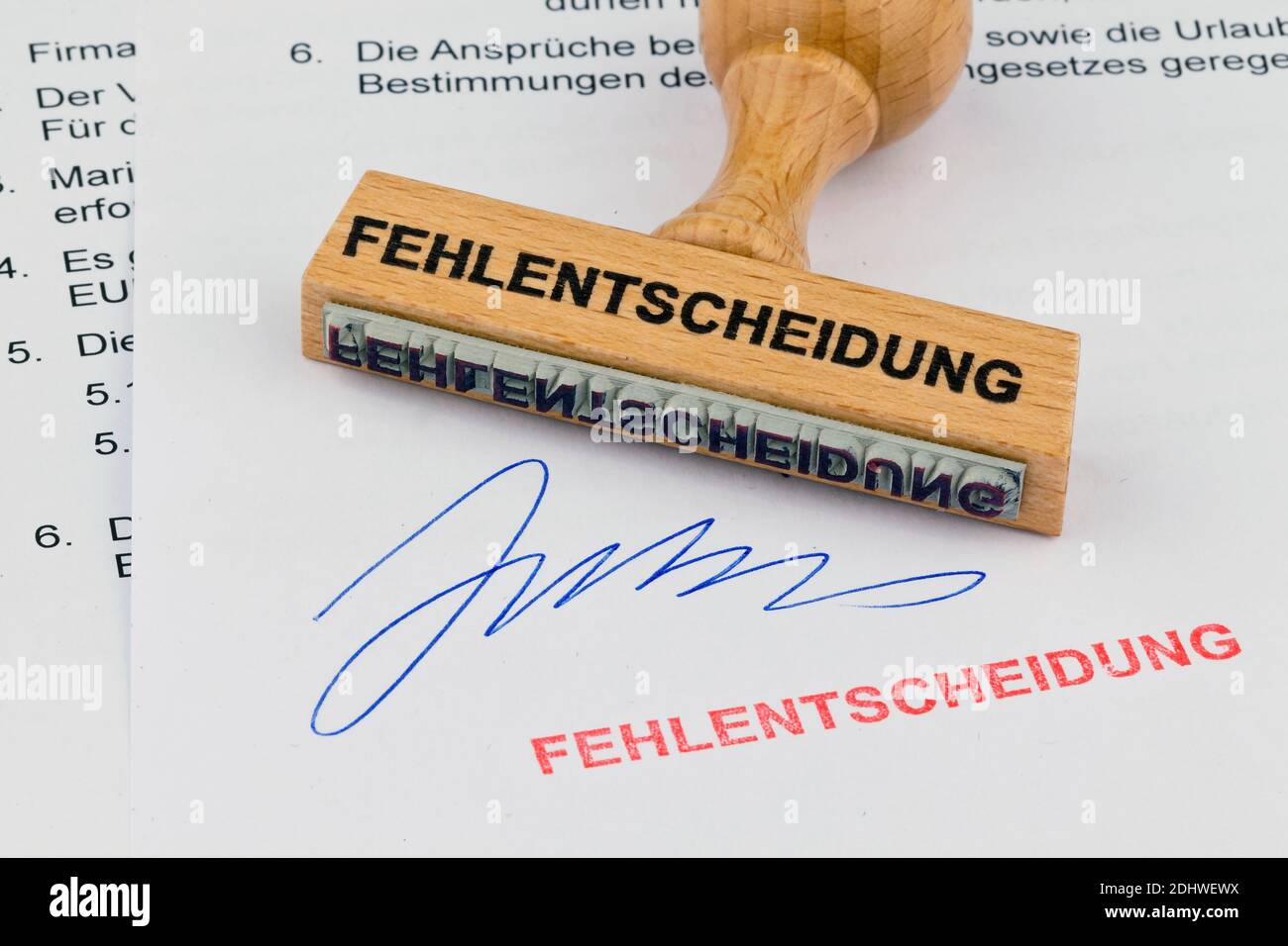 Ein Stempel aus Holz liegt auf einem Dokument. Aufschrift Fehlentscheidung Stock Photo