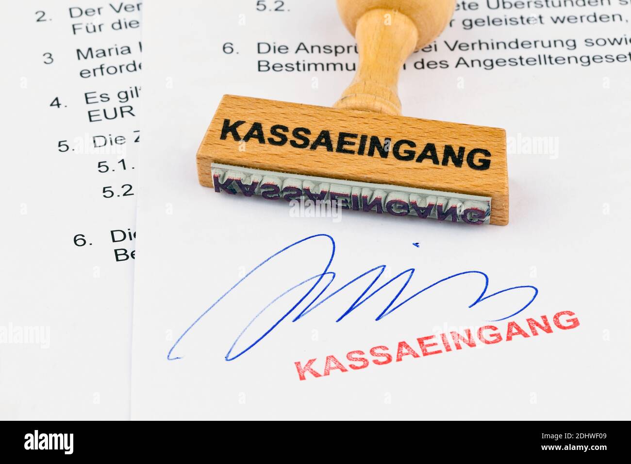Ein Stempel aus Holz liegt auf einem Dokument. Aufschrift Kassaeingang Stock Photo
