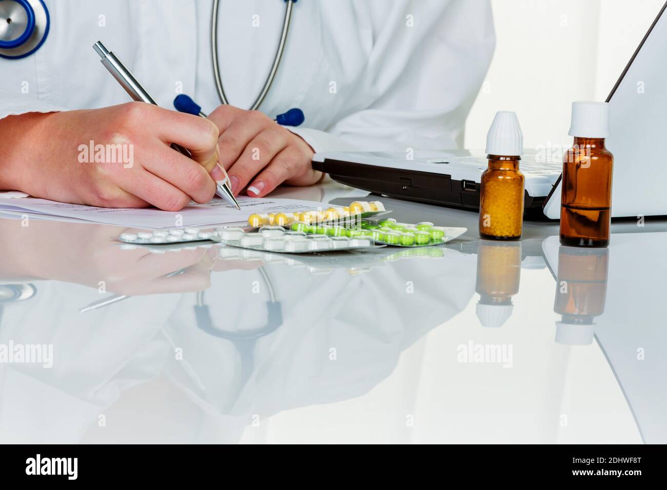Eine junge Ärztin verschreibt Medikamente. Rezeptpflichtige Tabletten werden vom Arzt verordnet. Stock Photo