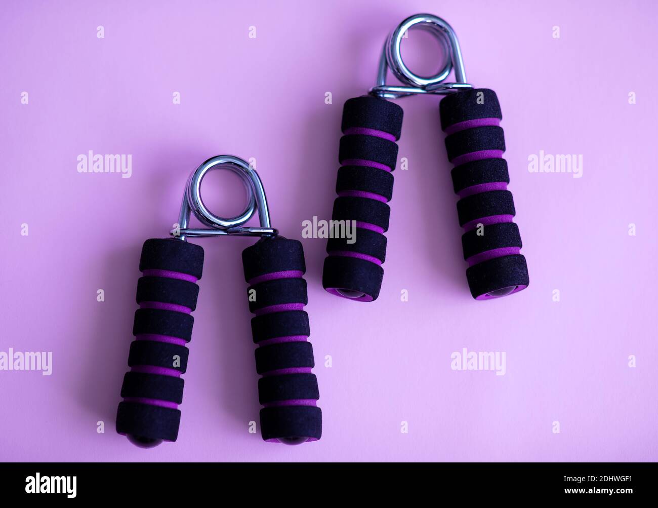 Hand grip strengthener for hand exerciser on a purple background Stock Photo