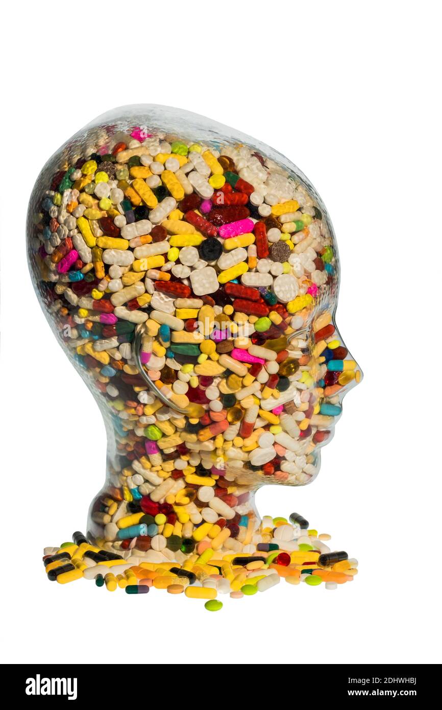 Ein Kopf aus Glas mit vielen Tabletten gefüllt. Symbolphoto für Medikamente, Mißbrauch und Tablettensucht. Stock Photo