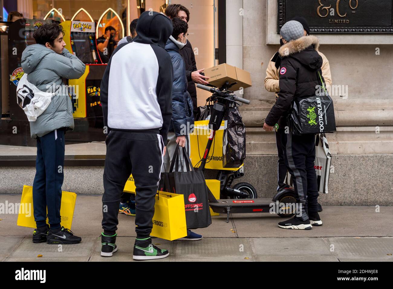 London, UK. 12 December 2020. Shoppers outside Selfridges in Oxford Street  with their shopping bags as the number of coronavirus cases rises in the  capital. Retailers are hoping that physical sales will