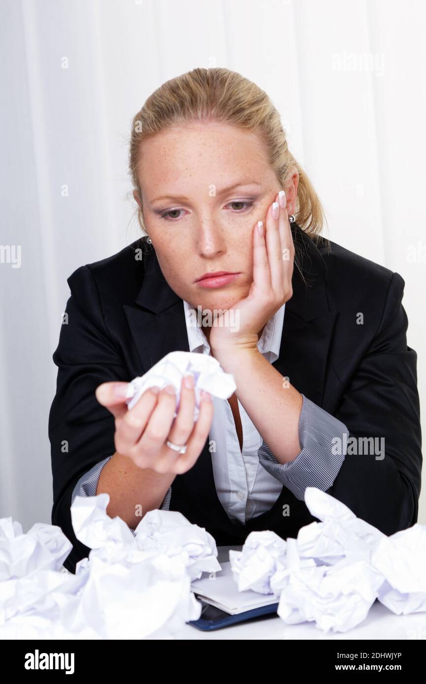 Eine Frau im Büro mit Papierknäuel. Ärger, Stress und Frust am Arbeitsplatz Stock Photo