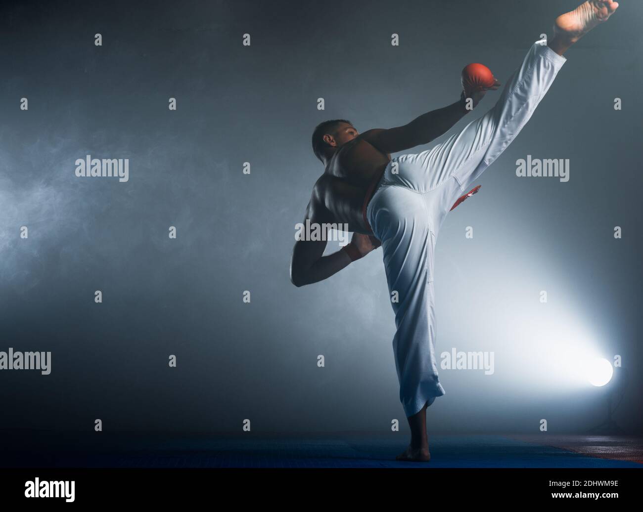 Young sporty man in white kimono training karate kata moves in gym Stock  Photo - Alamy