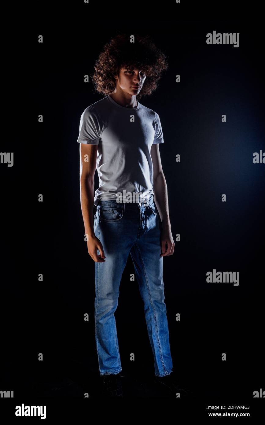 Skinny rock guy wearing  blue jeans pants isolated on black backgorund Stock Photo