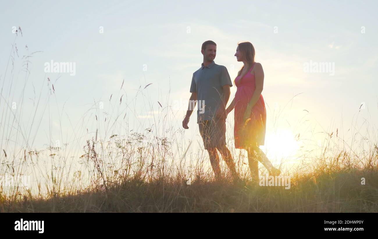 A friendly large family walks across the field at sunset Stock Photo ...