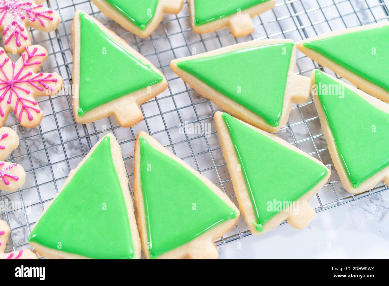 Decorating Christmas sugar cookies with royal icing and sprinkles Stock