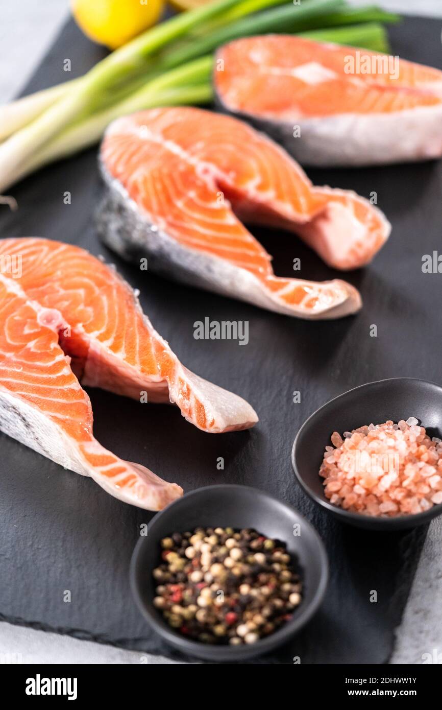 Farm-raised salmon steaks on a slate board Stock Photo - Alamy
