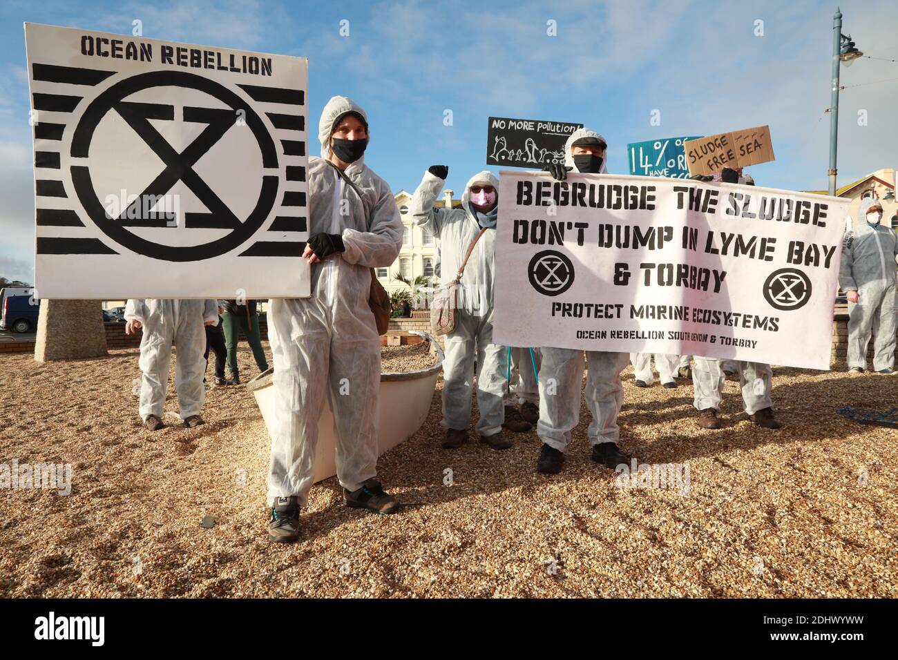 Teignmouth, South Devon, UK. 12th Dec, 2020. Members of Ocean Rebellion XR and the Red Rebels staged a peaceful protest in the seaside resort of Teignmouth. Protestors are calling for sludge dumping from Exmouth Docks to be stopped from dumping 10,000 tons of pollutants into an area of the sea where juvenile fish are developing.Locals feel angry that the sludge dumping took place during the lock down when protests could not legally take place. Credit: Natasha Quarmby/Alamy Live News Stock Photo