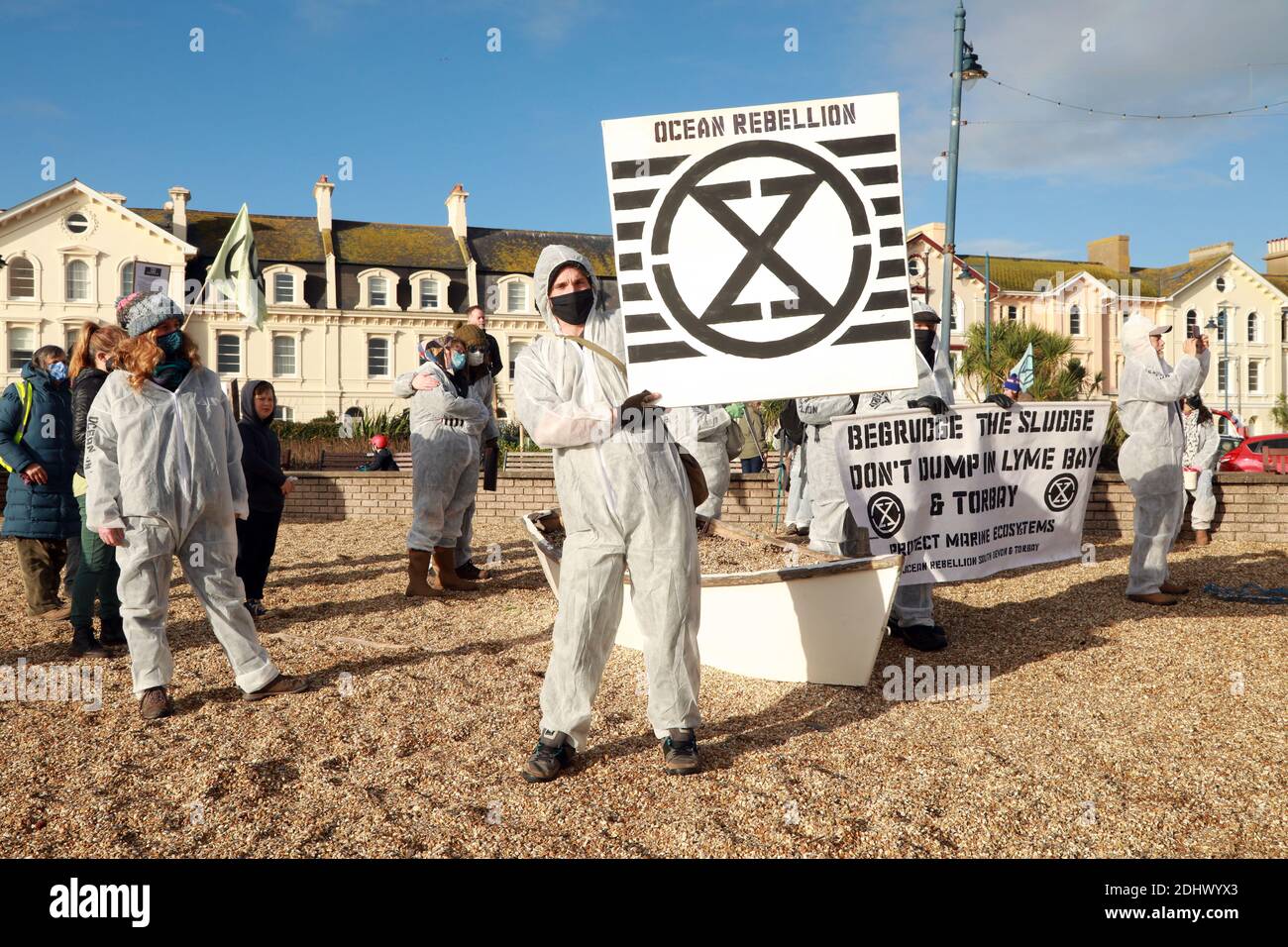Teignmouth, South Devon, UK. 12th Dec, 2020. Members of Ocean Rebellion XR and the Red Rebels staged a peaceful protest in the seaside resort of Teignmouth. Protestors are calling for sludge dumping from Exmouth Docks to be stopped from dumping 10,000 tons of pollutants into an area of the sea where juvenile fish are developing.Locals feel angry that the sludge dumping took place during the lock down when protests could not legally take place. Credit: Natasha Quarmby/Alamy Live News Stock Photo