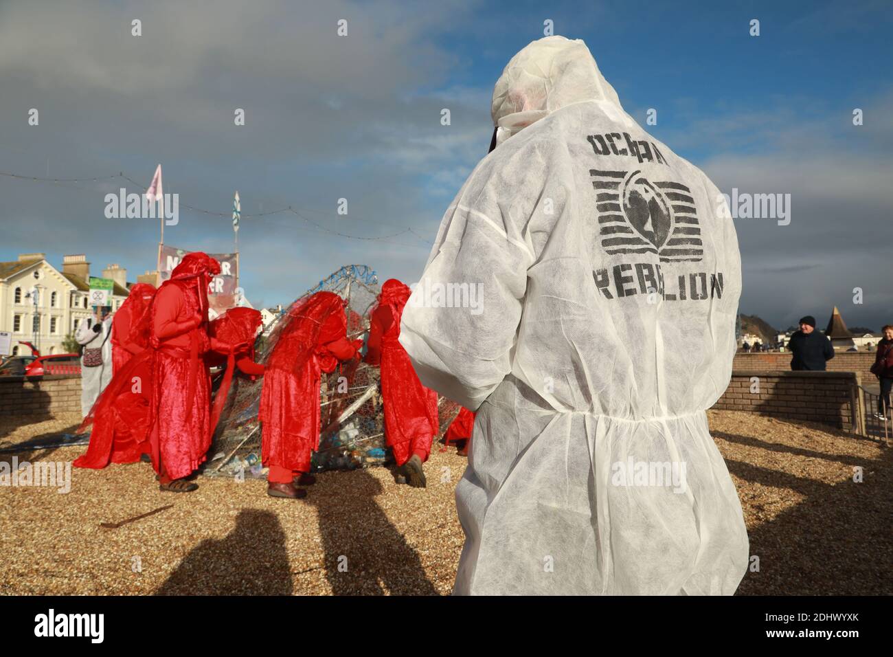 Teignmouth, South Devon, UK. 12th Dec, 2020. Members of Ocean Rebellion XR and the Red Rebels staged a peaceful protest in the seaside resort of Teignmouth. Protestors are calling for sludge dumping from Exmouth Docks to be stopped from dumping 10,000 tons of pollutants into an area of the sea where juvenile fish are developing.Locals feel angry that the sludge dumping took place during the lock down when protests could not legally take place. Credit: Natasha Quarmby/Alamy Live News Stock Photo