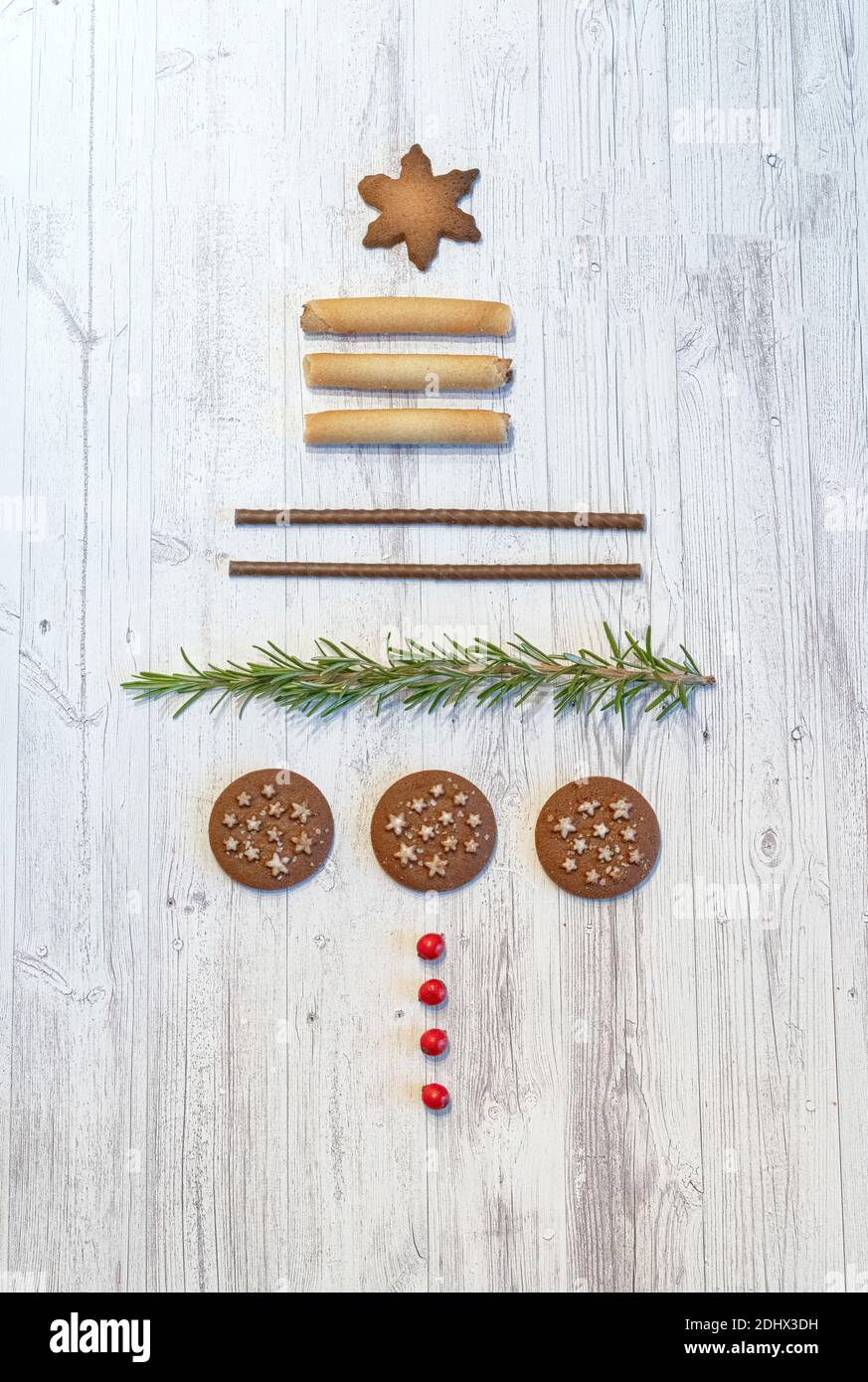 Conceptual Christmas tree made of cookies and fir tree needles on wood table background from above Stock Photo
