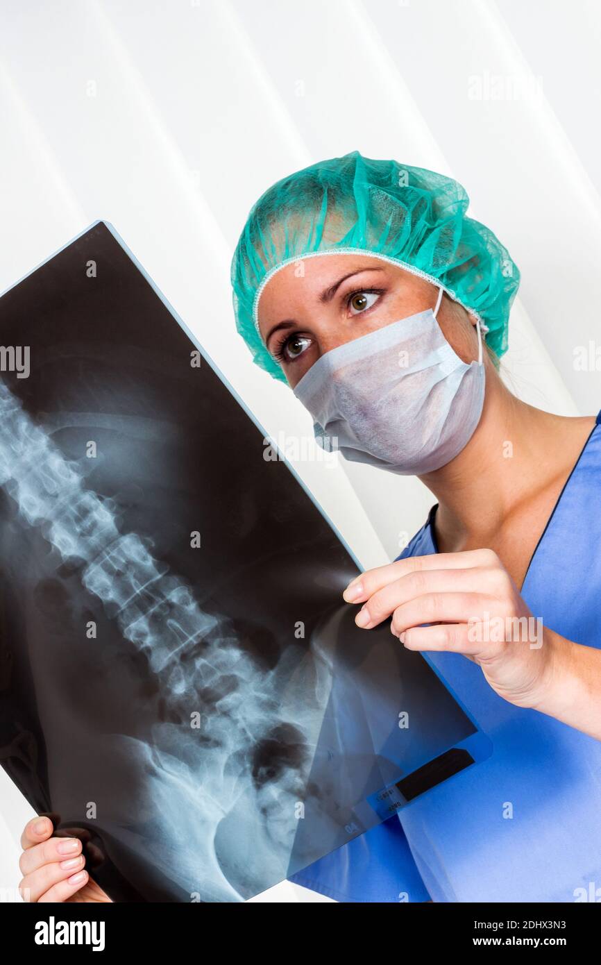 Eine junge Aerztin mit Stethoskop betrachtet ein Roentgenbild, MR: YES Stock Photo