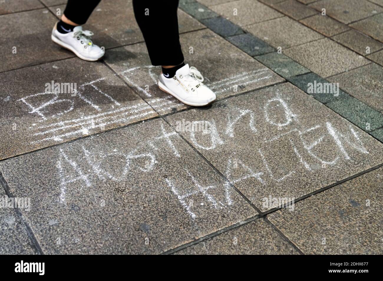 Request: 'Please keep your distance' on the floor in the pedestrian shopping zone in Dortmund, Germany, December 11th, 2020 Stock Photo