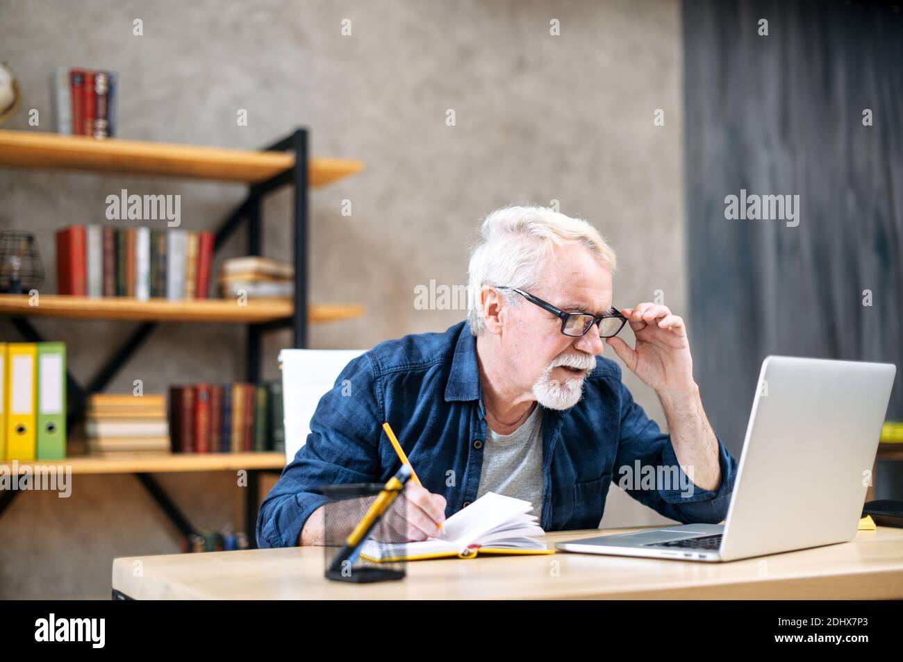 Older man using laptop for studying, working Stock Photo