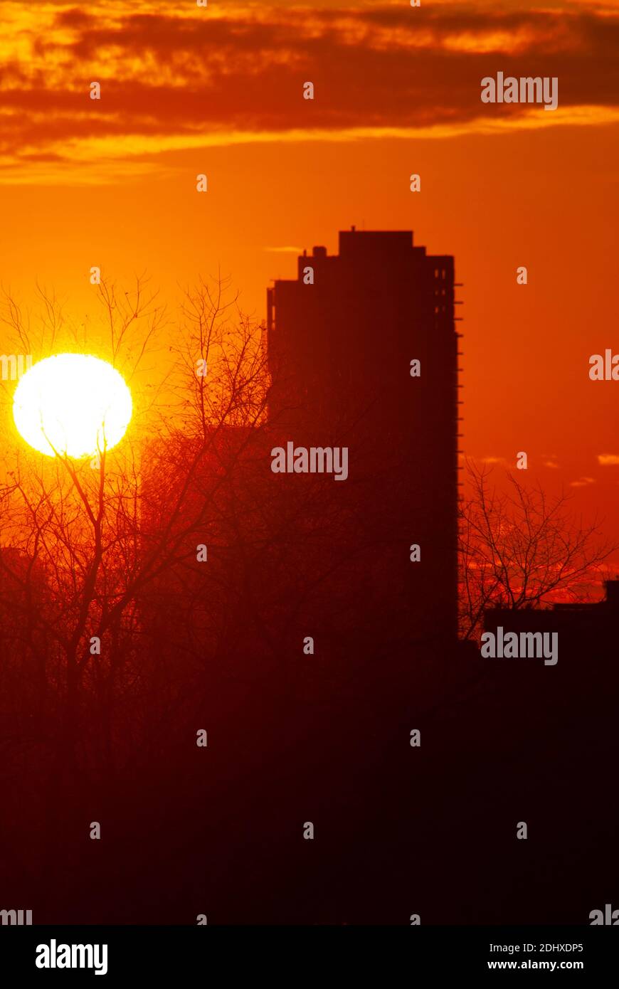 Sun setting behind buildings trees hi-res stock photography and images ...