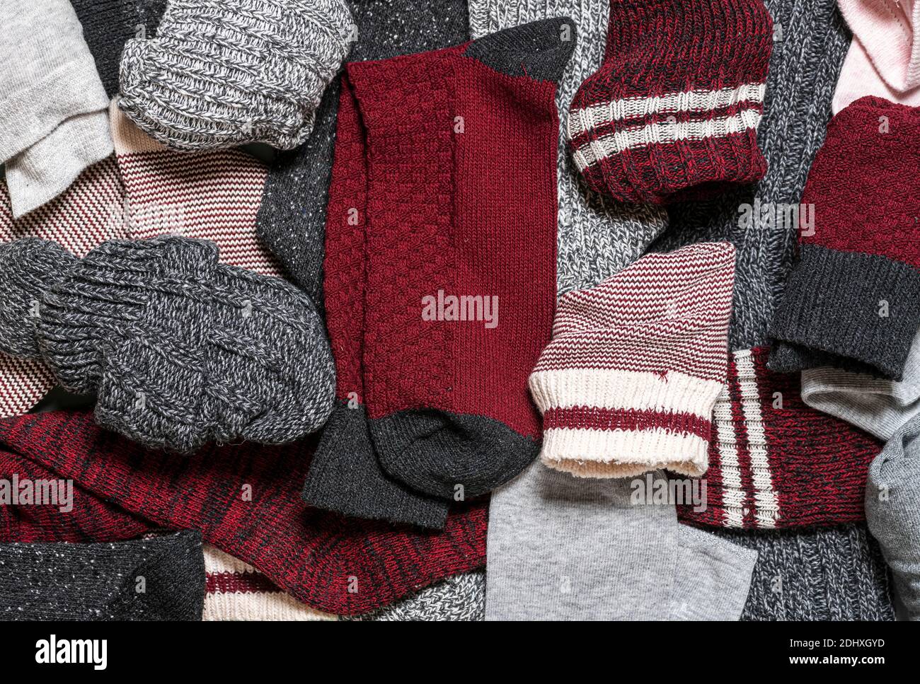 Above view with many multicolored cotton and wool socks. Close-up of a pile with diverse types of socks. Stock Photo
