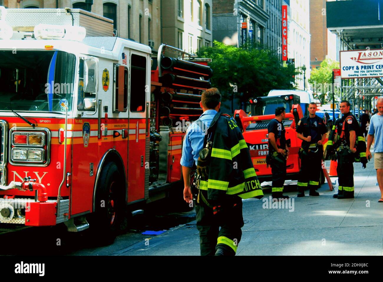 An FDNY fire captain walks away from the camera toward his engine crew after a false alarm in the city of New York Stock Photo