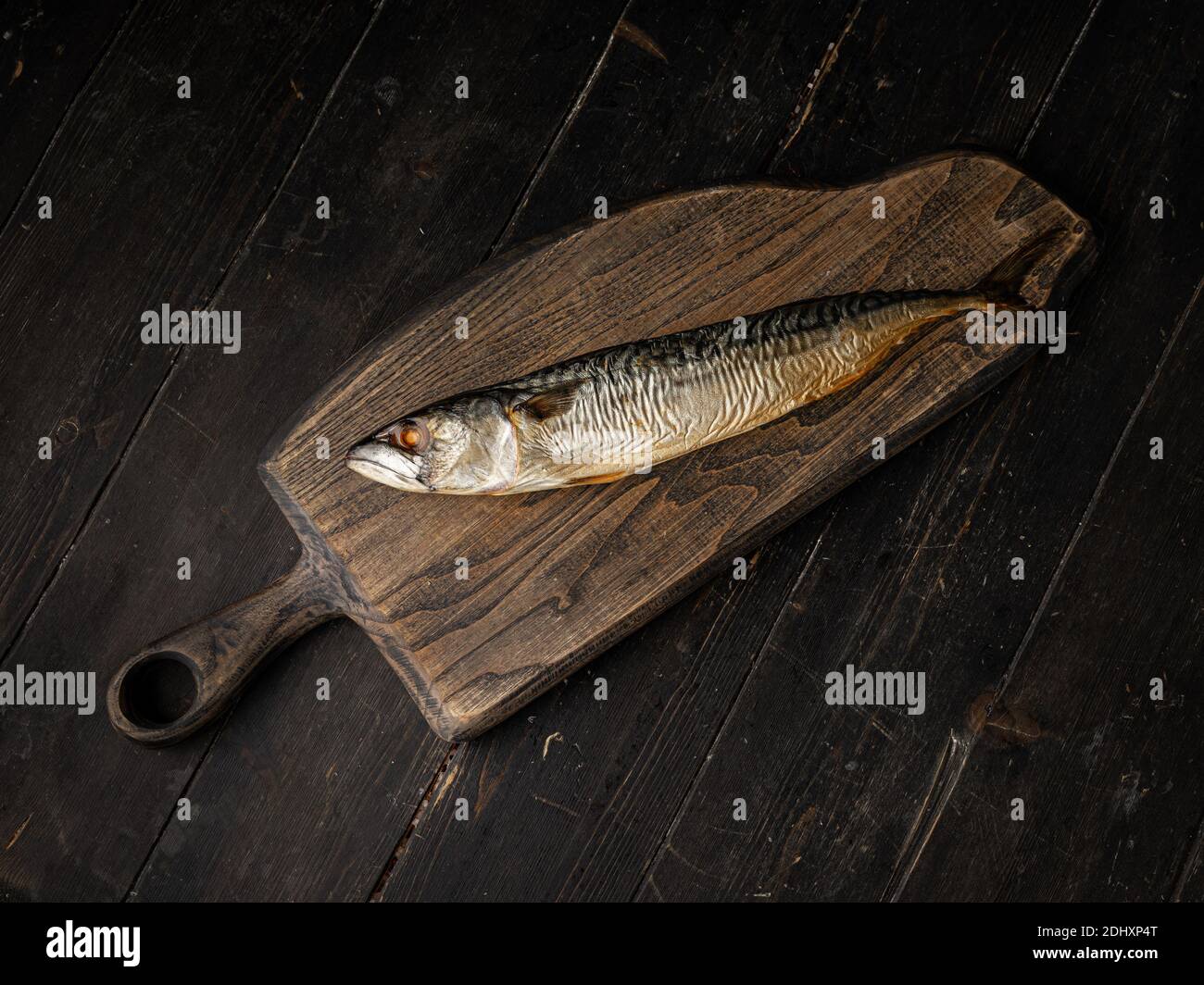 Cold smoked mackerel on a cutting board. On dark wooden background ...