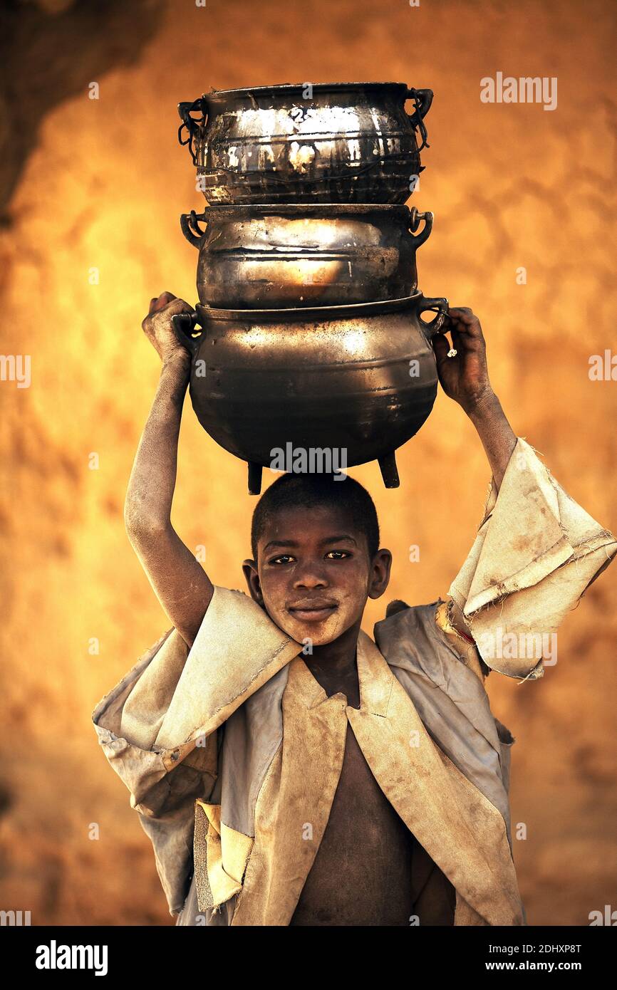 Young boy carrying pots on his head.in Niafunke ,Mali, West Africa. Stock Photo