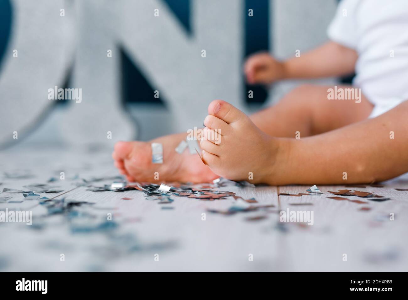 One years old child's feet on high chair while he is eating at kitchen dinner table Stock Photo