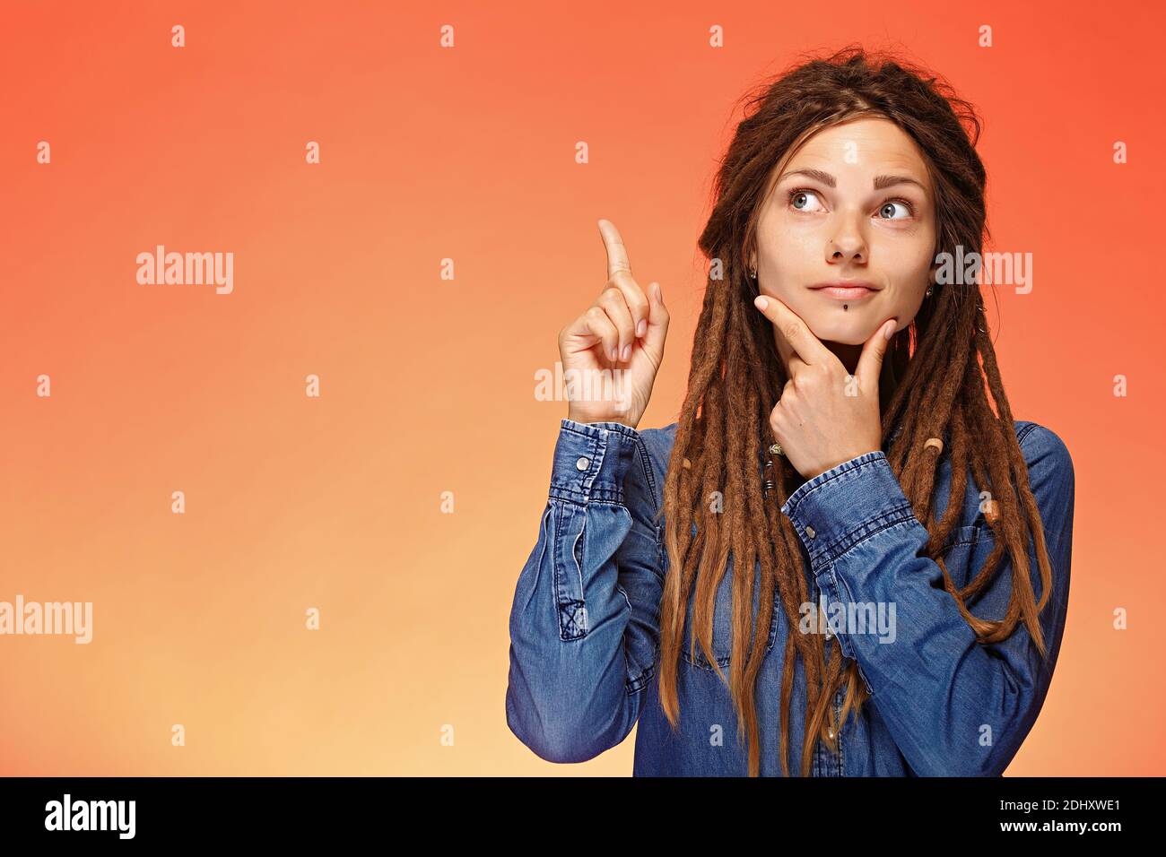 Portrait of pensive young woman who has good idea Stock Photo