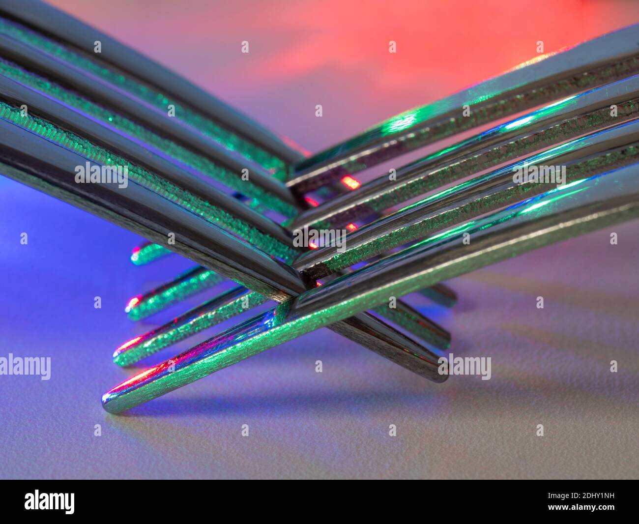 Abstract reflections of colored light in fork tines Stock Photo