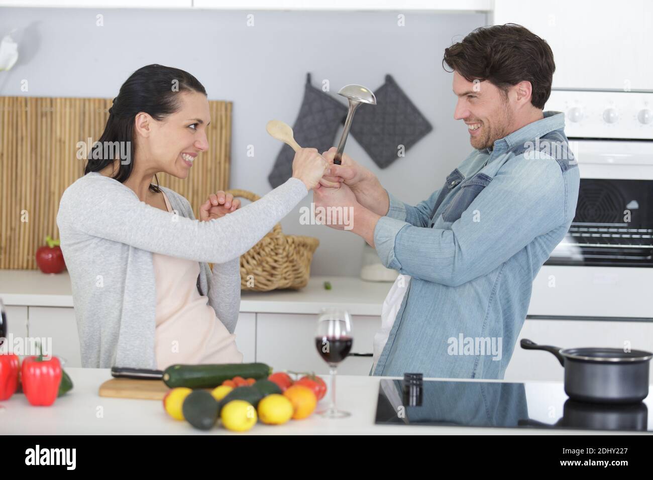 funny couple fights with utensils tools Stock Photo