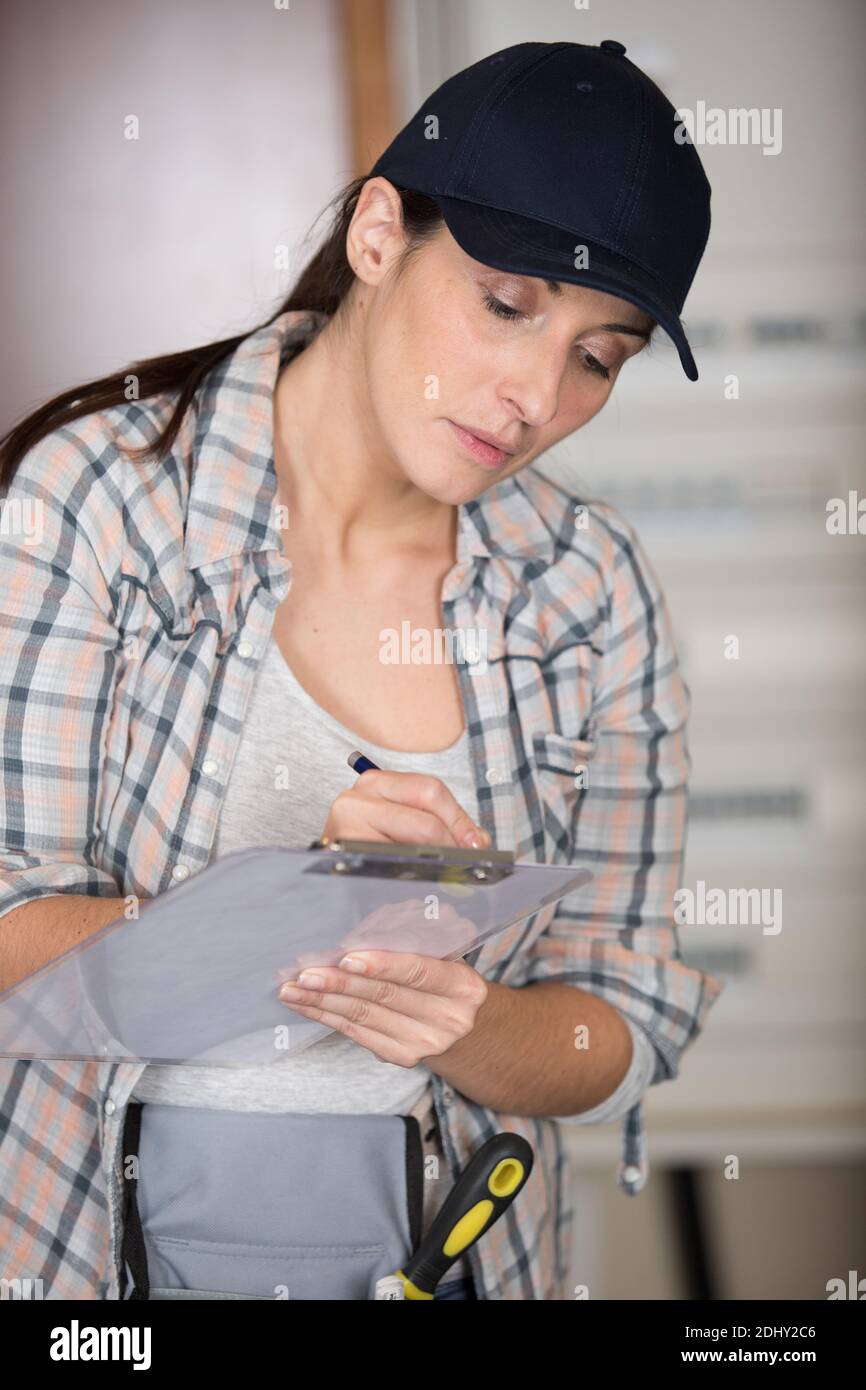 female manual worker writing on a clipboard Stock Photo - Alamy
